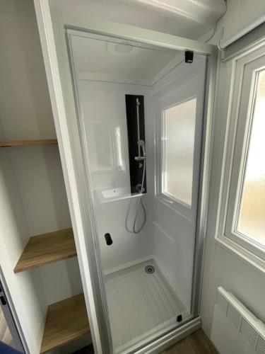 eine Dusche in einem kleinen Bad mit Glastür in der Unterkunft Mobilhome in Saint-Jean-de-Monts