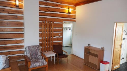 a room with a wooden wall with two chairs and a table at Holiday House Malá Skála in Malá Skála
