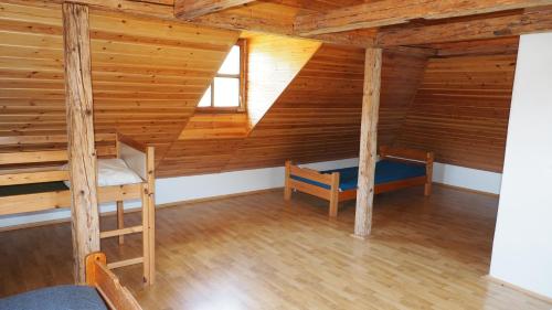 an attic room with two bunk beds and a window at Holiday House Malá Skála in Malá Skála