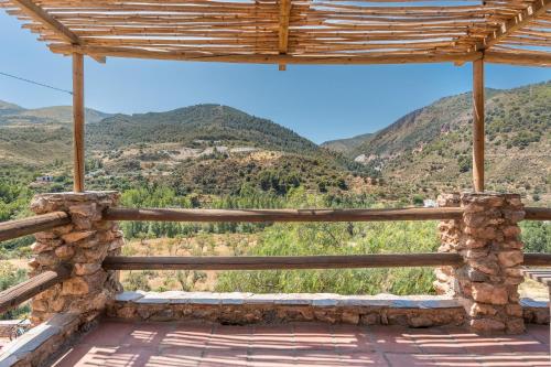 a wooden porch with mountains in the background at Off-Grid - Puerto Mika in Órgiva