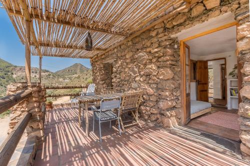 a wooden deck with a table and chairs on a building at Off-Grid - Puerto Mika in Órgiva
