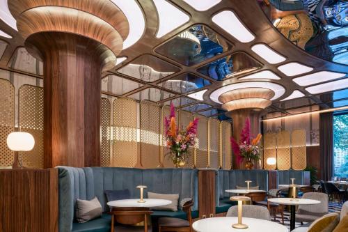 a restaurant with tables and chairs and a ceiling at Grand Hotel Centenari, Valencia, Autograph Collection in Valencia