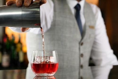 a man is pouring wine into a wine glass at Grand Hotel Centenari, Valencia, Autograph Collection in Valencia