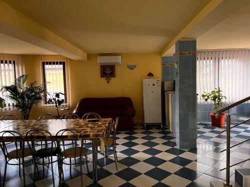 a living room with a table and chairs and a refrigerator at Vila Ovi Salin in Turda