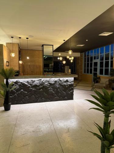 a lobby with a bar with a stone wall at Apartment in Gonio - PONTOS ROOMS in Itʼkhvisi