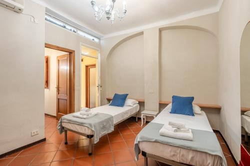 two beds in a room with blue pillows at I Fossi Apartment - Lucca in Lucca