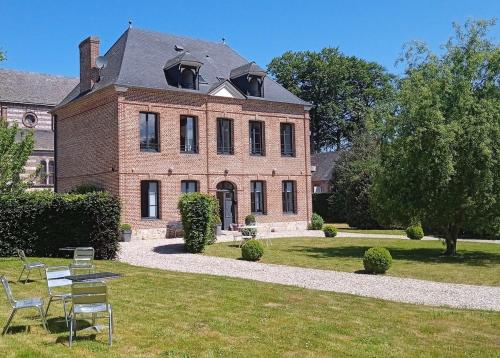 a large brick house with a table and chairs in front of it at La Durdent - Domaine du Presbytère in La Chapelle-sur-Dun