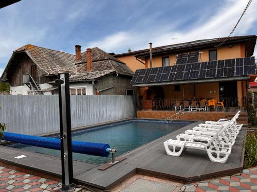 a swimming pool with lounge chairs and a swimming pool at Vila Ovi Salin in Turda