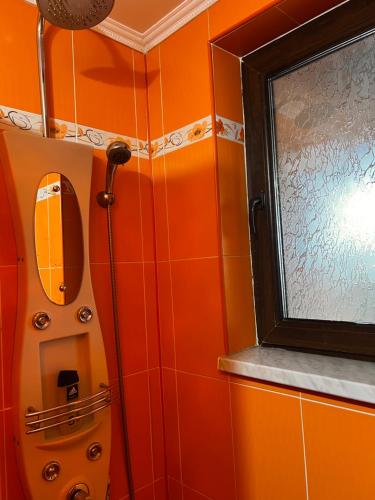 a bathroom with orange tiled walls and a mirror at Vila Ovi Salin in Turda
