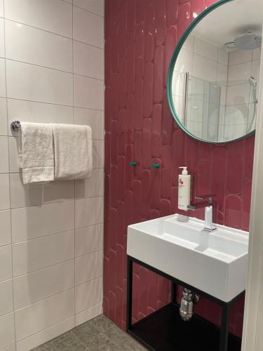 a bathroom with a white sink and a mirror at Good Morning Karlstad City in Karlstad