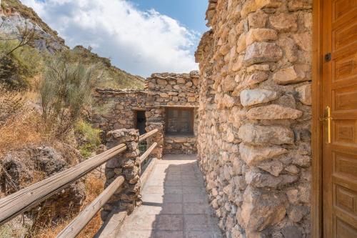 an entrance to a stone building with a wooden door at Off-Grid - Puerto Mika in Órgiva