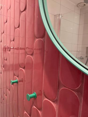 a bathroom with a red door with a mirror at Good Morning Karlstad City in Karlstad