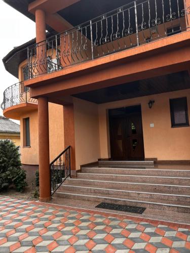 a building with stairs and a balcony with a door at Vila Ovi Salin in Turda