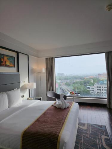 a hotel room with a large bed and a large window at Crowne Plaza Pune City Centre by IHG in Pune