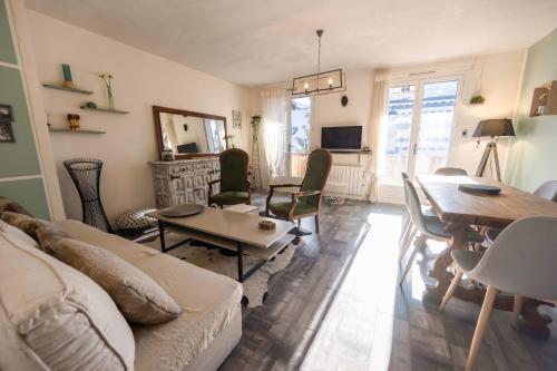 a living room with a couch and a table at Douce Altitude - Centre ville - Balcon in Barcelonnette