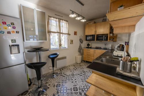 a kitchen with a sink and a refrigerator at Douce Altitude - Centre ville - Balcon in Barcelonnette