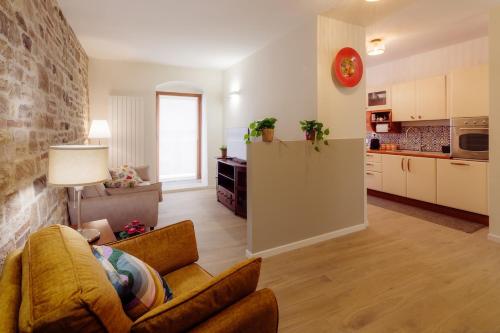 a living room with a couch and a kitchen at Winding Village Suite in Trevi