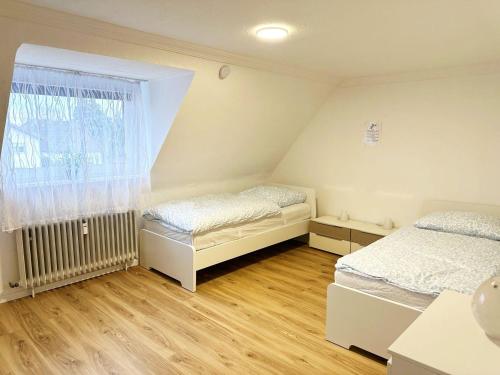 Dos camas en una habitación con ventana. en Work & Stay Apartment in Niederkassel, en Niederkassel