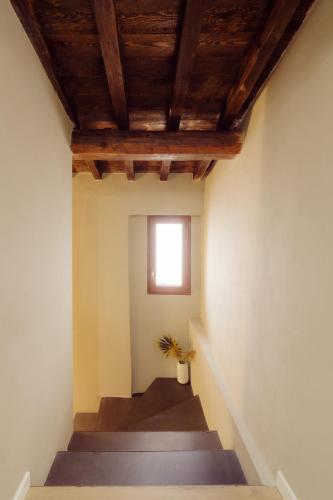 a stairway with a window and a plant in a vase at Winding Village Suite in Trevi