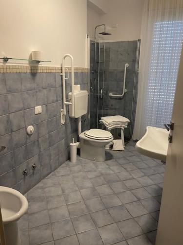 a bathroom with a toilet and a shower and a sink at Hotel Corfù in Pineto