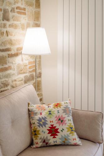 a pillow on a couch next to a lamp at Winding Village Suite in Trevi