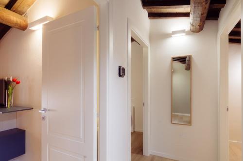 a hallway with a white door and a mirror at Winding Village Suite in Trevi
