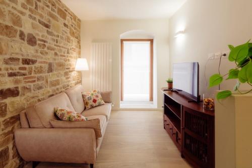 a living room with a couch and a tv at Winding Village Suite in Trevi