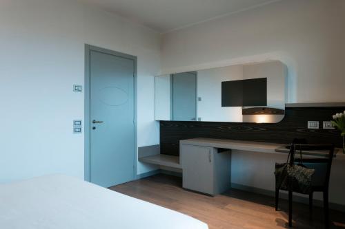 a kitchen with a desk and a television in a room at Grand Hotel Forlì in Forlì