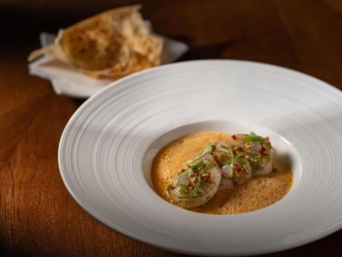 a white plate with a piece of food on a table at Platan Udvarhaz in Tata