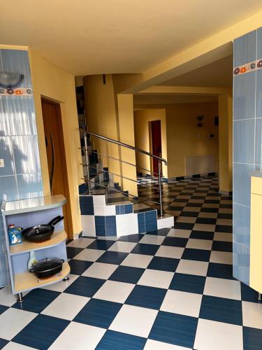 a lobby with blue and white checkered floor and stairs at Vila Ovi Salin in Turda
