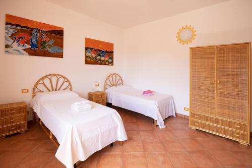 a bedroom with two beds and a mirror on the wall at Villa nel centro Salento - Free Wi-Fi in Ruffano