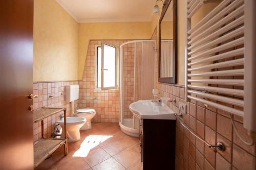 a bathroom with a toilet and a sink and a mirror at Villa nel centro Salento - Free Wi-Fi in Ruffano