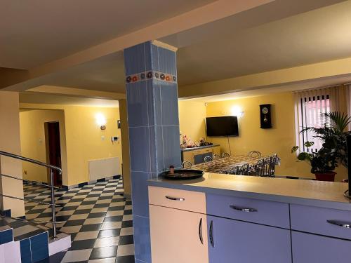 a kitchen with a counter and a living room at Vila Ovi Salin in Turda