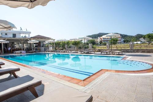 a large swimming pool with tables and chairs at Olevia Comfort in Faliraki