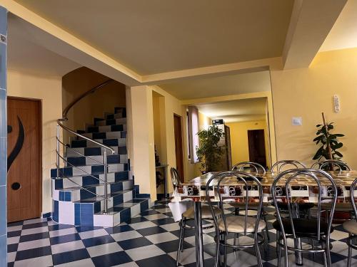 a room with a table and chairs and a staircase at Vila Ovi Salin in Turda