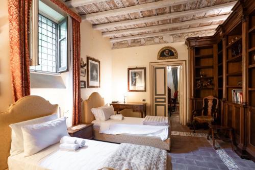 Un dormitorio con dos camas y una ventana. en Principe di Castelnuovo Historical Suites, en Palermo