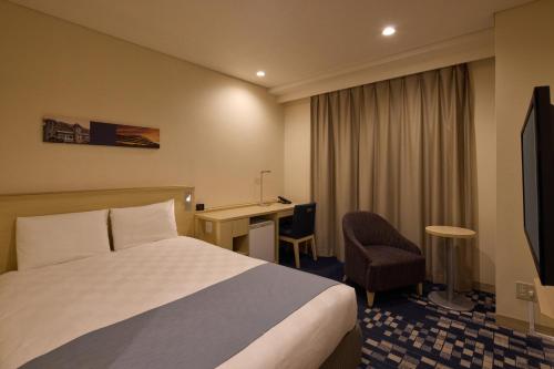a hotel room with a bed and a desk at Kobe Sannomiya Tokyu REI Hotel in Kobe