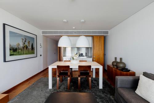 a kitchen and living room with a table and a couch at Troia Design Hotel in Troia