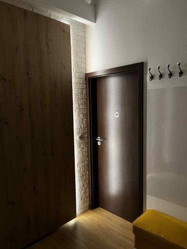 a brown door in a room with a brick wall at Apartamenty Rubikon in Kraków