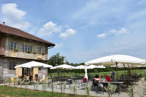 a restaurant with tables and umbrellas in front of a building at La Locanda della Mandria in Venaria Reale