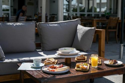 a table with plates of food and drinks on it at Olevia Comfort in Faliraki