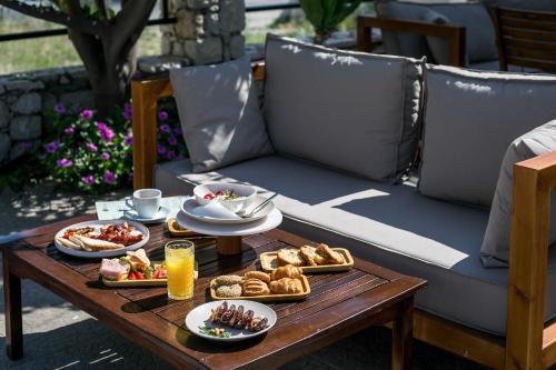 a table with plates of food and drinks on it at Olevia Comfort in Faliraki