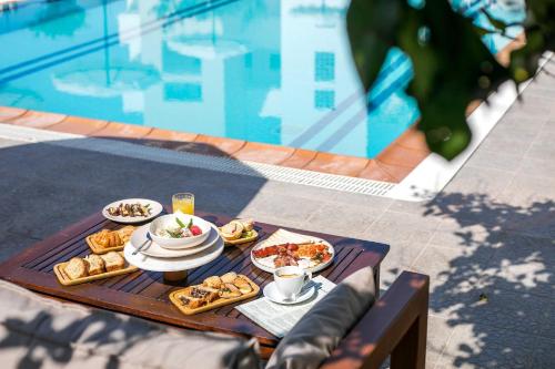 a tray of food on a table next to a pool at Olevia Comfort in Faliraki