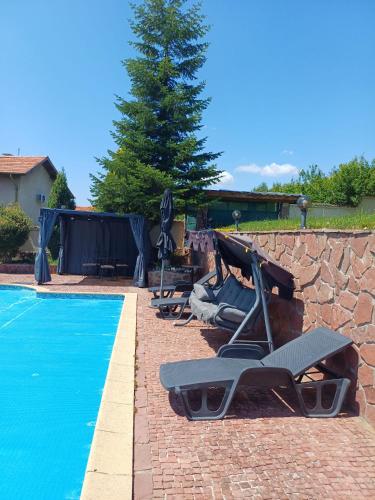 a group of lounge chairs next to a swimming pool at Villa Villekulla in Chukovezer