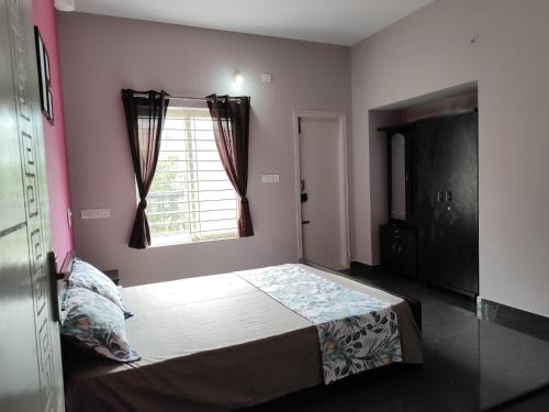 a bedroom with a bed and a window at Samuels Comfort Homes in Bengaluru