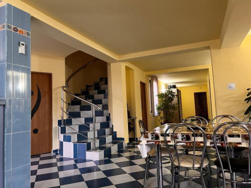 a dining room with a table and chairs and a staircase at Vila Ovi Salin in Turda