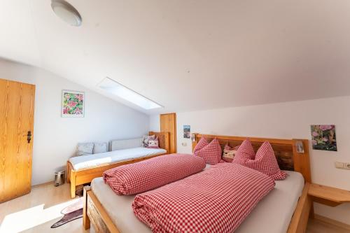a bedroom with two beds with red and white pillows at Adlerhof in Samerberg