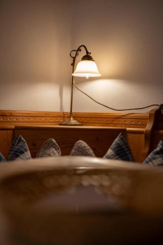 a lamp sitting on top of a bed at Adlerhof in Samerberg
