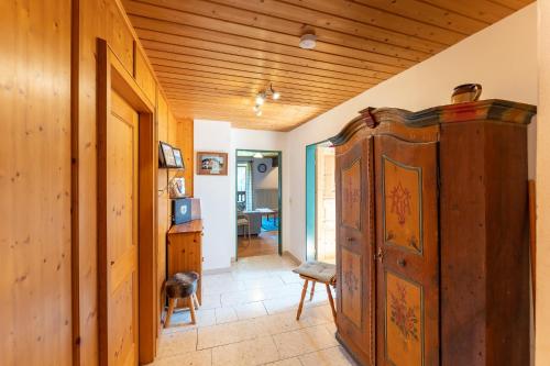 a room with a large wooden cabinet and a hallway at Adlerhof in Samerberg