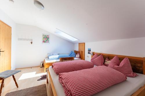 a bedroom with two beds with red and white pillows at Adlerhof in Samerberg